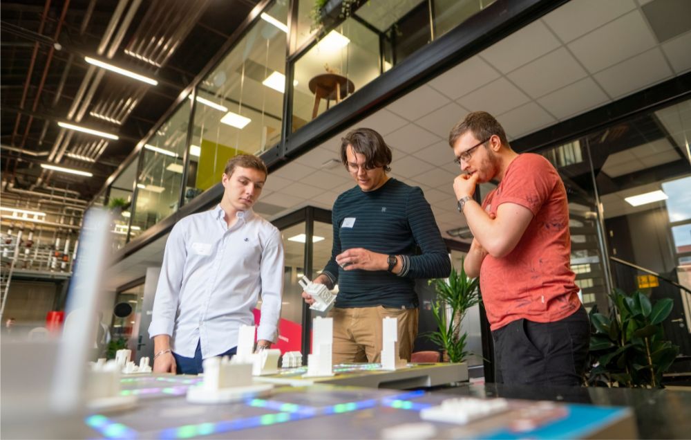 Drie studenten bestuderen een testopstelling bij Biltin
